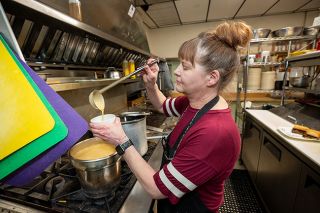 Rachel Thompson/News-Register##American Legion cook Laura Marcin dips up a serving of bacon-beer-cheddar cheese dipping sauce for the Frencheesy, a roast beef sandwich available this month during the Melt Down fundraiser. The sauce is the star of the show, Marcin said. She has to make a new pot daily because it sells out fast. The Frencheesy, pictured below, is among the Melt Down specials offered at 44 sites in Yamhill County through Feb. 28, with a portion of the proceeds going to the YCAP food bank.