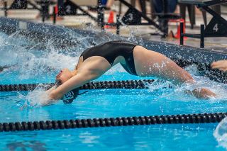 Rachel Thompson/News-Register##Senior Maddy Davenport pushes off the blocks in the 100-yard backstroke event during McMinnville’s dual meet against Forest Gove on Tuesday. Davenport finished second in the event with a time of 1:14.71.