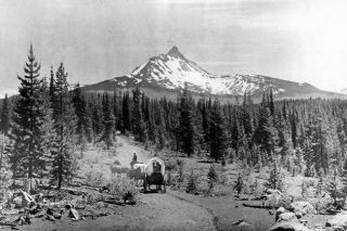 Image: Cascade Volunteers##A wagon crosses the Old Santiam Wagon Road near Sisters, sometime in the late 1800s.