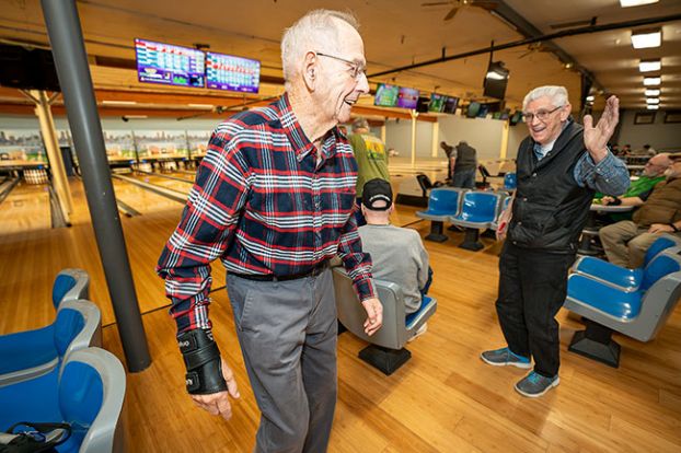 Rachel Thompson/News-Register##Tuesday Senior League President Larry Hartman, right, congratulates Roger Miller on a successful roll during a game at Walnut City Lanes. The men say bowling is great exercise for seniors — and a great way to socialize.