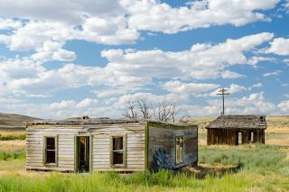 Image: Gary Halvorson/ Oregon State Archives##Ruined buildings in the old ghost town of Westfall as they appeared in 2011. The roofless house in the foreground is what remains of Jasper Westfall’s home.