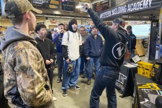 Starla Pointer/News-Register##Fabrication students from McMinnville High School and Redmond High surround Quacy Wilson, leader of the Blue Collar Tour, during a visit to Mac High last week. Instructors from the Western Welding Academy and some local tradespeople spent the morning demonstrating welding and other skills and talking about careers in the trades.