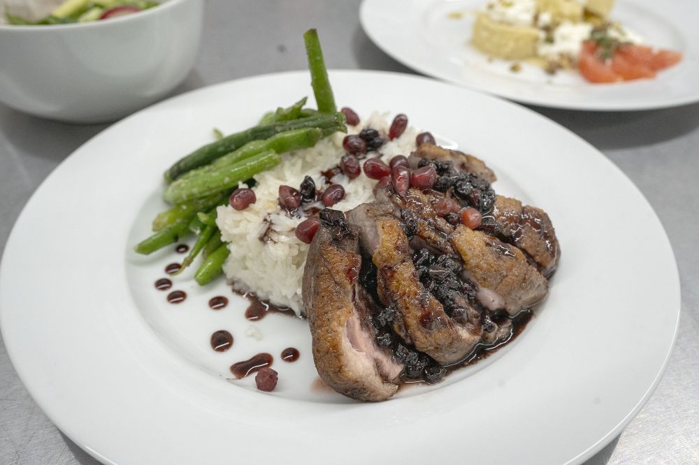 Rachel Thompson/News-Register##The DHS team’s entree: Roasted duck breast with miso and pomegranate sauce, rice and green beans. Dessert of lime sponge cake and citrus coulis is in the background.