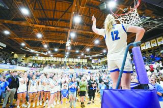 Rachel Thompson/News-Register##Junior guard Eliza Nisly holds up her piece of the state championship net to the roaring Amity crowd. Nisly was named second team All-State for the second year in a row.