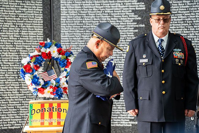 Rachel Thompson/News-Register##After the Honor Guard folded the flag, Angel Mendoza, left, United Veterans Honor Guard Commander, pauses in reflection of the service and sacrifice of veterans during the opening ceremony for the Oregon Memorial Traveling Wall, Friday, March 28, at Evergreen Aviation & Space Museum. At right is Honor Guard member Staff Sergeant Bobb Fleming. Rachel Thompson/News-Register##After the Honor Guard folded the flag, Angel Mendoza, left, United Veterans Honor Guard Commander, pauses in reflection of the service and sacrifice of veterans during the opening ceremony for the Oregon Memorial Traveling Wall, Friday, March 28, at Evergreen Aviation & Space Museum. At right is Honor Guard member Staff Sergeant Bobb Fleming.