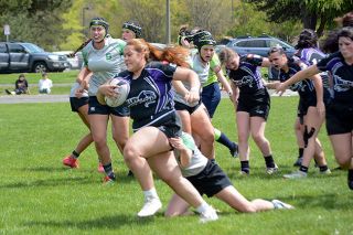Emily Bonsant/News-Register##Pricila Soto breaks free from a Summit tackler following a scrum. In the background, the wear and tear of the game is visible, as several members of the Panthers team were injured in the April 26 contest.