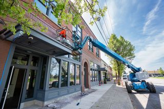 Rachel Thompson/News-Register##A worker from District Painting Company of Portland uses a lift in mid-April to put finishing touches on the exterior of the Merchant Block building in Dayton. Twin Towers, part of the Stoller Group, is converting the former bank building into retail space on the ground floor and hotel rooms upstairs under the management of Escape Lodging. A soft opening of the lodging space is planned on Memorial Day weekend, with a community opening in June. Rachel Thompson/News-Register##A worker from District Painting Company of Portland uses a lift in mid-April to put finishing touches on the exterior of the Merchant Block building in Dayton. Twin Towers, part of the Stoller Group, is converting the former bank building into retail space on the ground floor and hotel rooms upstairs under the management of Escape Lodging. A soft opening of the lodging space is planned on Memorial Day weekend, with a community opening in June.