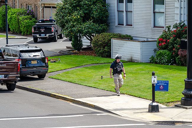 Rachel Thompson/News-Register##Sgt. Todd Adams of the Oregon State Police cleans up after determining a “suspicious package” was not a threat — it was rolled up sacks, McMinnville Police Chief Cord Wood said. “It turns out it was not anything dangerous,” Wood said. Mac Police was notified of a suspicious package on the lawn of the County Commissioner building at the corner of Evans and Fifth streets at about noon Wednesday. To officers, the package appeared to be round in shape with a fuse wrapped at the top. Mac Police cleared a one-block perimeter in all directions from the device and called in Adams to investigate. “We keep people far away in case something goes off,” Wood said. “We appreciate the community’s patience for allowing us to deal with the situation, as it can impact the workday,” Wood said, adding it’s helpful to have partners like OSP with additional training in explosives available to assist. Rachel Thompson/News-Register##Sgt. Todd Adams of the Oregon State Police cleans up after determining a “suspicious package” was not a threat — it was rolled up sacks, McMinnville Police Chief Cord Wood said. “It turns out it was not anything dangerous,” Wood said. Mac Police was notified of a suspicious package on the lawn of the County Commissioner building at the corner of Evans and Fifth streets at about noon Wednesday. To officers, the package appeared to be round in shape with a fuse wrapped at the top. Mac Police cleared a one-block perimeter in all directions from the device and called in Adams to investigate. “We keep people far away in case something goes off,” Wood said. “We appreciate the community’s patience for allowing us to deal with the situation, as it can impact the workday,” Wood said, adding it’s helpful to have partners like OSP with additional training in explosives available to assist.