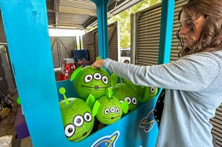 Rachel Thompson/News-Register##Kathryn Ellis, academic advisor at the Chemeketa Yamhill Valley Campus, adjusts alien decorations inside a claw machine, modeled after “The Claw” from the movie “Toy Story,” for the campus’ float in Saturday’s UFO Festival parade. Chemeketa staff have an entry every year; participating brings people together and reminds the community about the offerings at the community college, Ellis said.