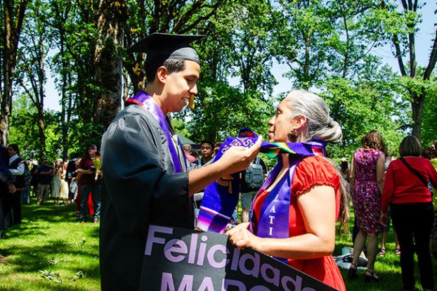 Rachel Thompson/News-Register##Graduate Marcos Cortes places his stoles over his mother, Maria Cortes, following Linfield’s commencement. “She graduated high school with me in her womb, and I wanted to graduate with her by my side,” said Marcos, the first in his family to earn a college degree. “She’s been my pillar of strength since I was a kid. She didn’t have it easy, and seeing her develop into the woman she is inspired me to become a man that reflects a mother like that. This moment wasn’t just mine; it was ours.” Born in León, Mexico, Marcos earned a bachelor’s in exercise science and plans to become a physical therapist. His brother, Angel, will graduate from Mac High on Friday.