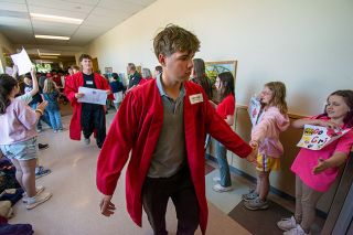 Rachel Thompson/News-Register##On the day before graduation, McMinnville High School senior Tanner Leikam high-fives fourth-grader Olivia Libonati during the annual parade of graduates at Newby Elementary School. He’s joined by fellow senior Metolius Halloran-Steiner and 75 classmates. Newby students lined the halls, waving handmade signs and cheering, “Let’s go Grizzlies!” and “Grizz-LIES! Grizz-LIES!” In a tradition that began in 2013, Mac High seniors visit their former elementary schools to inspire younger students to look ahead to their own graduations. Rachel Thompson/News-Register##On the day before graduation, McMinnville High School senior Tanner Leikam high-fives fourth-grader Olivia Libonati during the annual parade of graduates at Newby Elementary School. He’s joined by fellow senior Metolius Halloran-Steiner and 75 classmates. Newby students lined the halls, waving handmade signs and cheering, “Let’s go Grizzlies!” and “Grizz-LIES! Grizz-LIES!” In a tradition that began in 2013, Mac High seniors visit their former elementary schools to inspire younger students to look ahead to their own graduations.