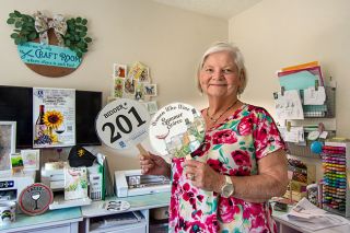 Rachel Thompson/News-Register##Danna Bone, who does community service as a member of Soroptimist International of McMinnville, shows off auction paddles she created for the club’s fundraising Women Who Wine Summer Soiree. Bone also uses her graphic design skills to make brochures and create the club newsletter. Rachel Thompson/News-Register##Danna Bone, who does community service as a member of Soroptimist International of McMinnville, shows off auction paddles she created for the club’s fundraising Women Who Wine Summer Soiree. Bone also uses her graphic design skills to make brochures and create the club newsletter.