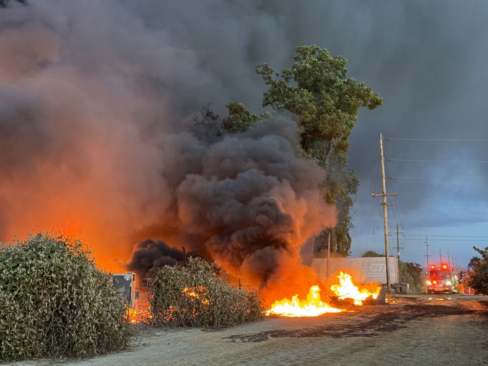 Rusty Rae/News-Register##Carlton Fire Chief Tim Jech said numerous pallets, the house and parked cars caught fire. Wind and a lack of water at the scene complicated the incident.