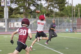 Lincoln High School wide receiver Reed Eldrige catches a pass from his quarterback during a seven-on-seven scrimmage on Maxwell Field at Memorial Stadium on June 22. In the background, Spencer Payne (former McMinnville High School player and coach) runs with the play as an official during the camp. 
Rusty Rae/News-Register