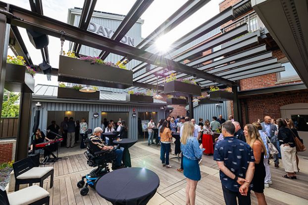 Rachel Thompson/News-Register##Dayton residents and people who worked on the inn project gather on the patio in back to celebrate its grand opening. Escape Lodging will operate the 12-room boutique hotel, which was constructed in a vintage building that once held a bank. Retail businesses are planned for the ground floor facing Ferry Street.