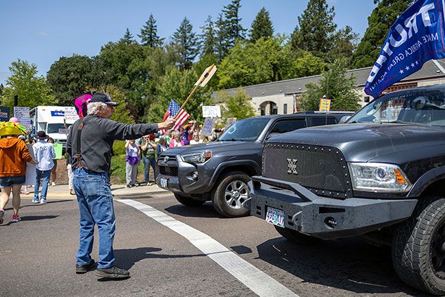 Rachel Thompson/News-Register file photo##Dan Kealey of Grand Ronde presents his sign to a truck driver waving a Trump flag during the No Kings protest in McMinnville on June 14. Rachel Thompson/News-Register file photo##Dan Kealey of Grand Ronde presents his sign to a truck driver waving a Trump flag during the No Kings protest in McMinnville on June 14.