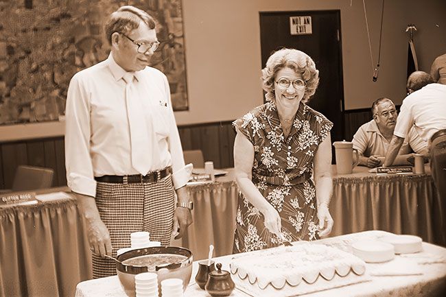 (July 2, 1980) McMinnville City Manager Joe Dancer’s 20 years of service to the city were recognized at a surprise gathering Tuesday night following the City Council meeting. Dancer watches as his wife, Coral, cuts cake prepared for the event. (July 2, 1980) McMinnville City Manager Joe Dancer’s 20 years of service to the city were recognized at a surprise gathering Tuesday night following the City Council meeting. Dancer watches as his wife, Coral, cuts cake prepared for the event.