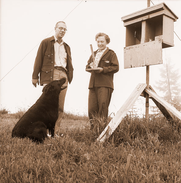 News-Register file photo##(July 5, 1960) Oregon Forestry Department representative Cliff Ebert of Forest Grove consults with Eleanor Mitchell of Yamhill, on Trask Mountain, about her weather information. Eleanor’s big dog, Mike, looks on. News-Register file photo##(July 5, 1960) Oregon Forestry Department representative Cliff Ebert of Forest Grove consults with Eleanor Mitchell of Yamhill, on Trask Mountain, about her weather information. Eleanor’s big dog, Mike, looks on.