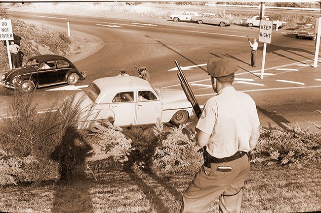 News-Register file photo##(July 11, 1965) County law enforcement officers wait at the intersection of Highways 47 and 99W Wednesday evening, shotguns ready. The roadblock was set up after local authorities were informed that two ex-convicts, wanted in connection with a number of Oregon crimes, were heading from Gaston to McMinnville. The two hour roadblock was called off after those giving the tip looked at pictures of the two wanted men and decided that they didn’t resemble the ex-convicts after all. News-Register file photo##(July 11, 1965) County law enforcement officers wait at the intersection of Highways 47 and 99W Wednesday evening, shotguns ready. The roadblock was set up after local authorities were informed that two ex-convicts, wanted in connection with a number of Oregon crimes, were heading from Gaston to McMinnville. The two hour roadblock was called off after those giving the tip looked at pictures of the two wanted men and decided that they didn’t resemble the ex-convicts after all.