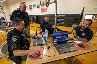 Rachel Thompson/News-Register##Law enforcement officers neutralize an active shooter in a digital simulation in Sheridan. From left, Sgt. Andrew McMahon with the Yamhill County Sheriff’s Office, Bureau of Prisons Lt. Bradley Holbrook with FCI–Sheridan, and Evan Burt, K9 handler with the McMinnville Police Department, make first contact with the “shooter” as instructor Pete Kelting with C3 Pathways looks on. Rachel Thompson/News-Register##Law enforcement officers neutralize an active shooter in a digital simulation in Sheridan. From left, Sgt. Andrew McMahon with the Yamhill County Sheriff’s Office, Bureau of Prisons Lt. Bradley Holbrook with FCI–Sheridan, and Evan Burt, K9 handler with the McMinnville Police Department, make first contact with the “shooter” as instructor Pete Kelting with C3 Pathways looks on.