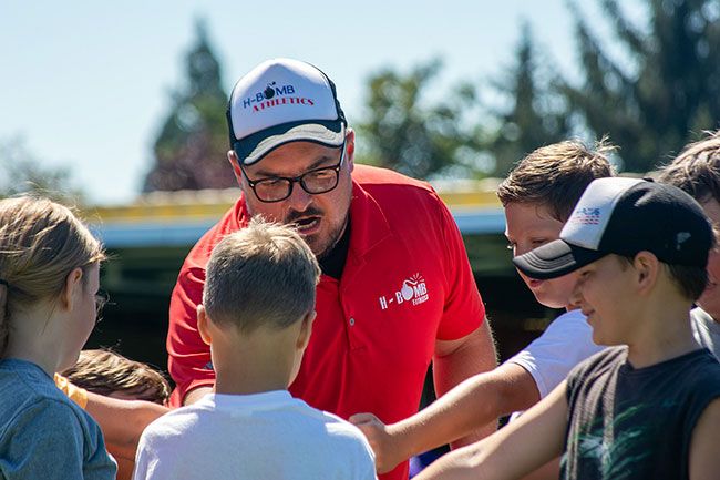 Nathan Ecker/The News-Register##H-Bomb Fitness owner Kyle Matson encourages his Moving Tigers athletes to stack their hands in the middle of a group circle following a 45 minute training session at the Yamhill Carlton Soccer Club turf fields in Carlton. Matson (owner of H-Bomb Fitness in Carlton) has begun running bi-weekly athletic camps for kids in first through fifth grade with the purpose of fostering opportunities of physical growth for youth who are hesitant to begin sports. Conversations with parents about their child’s lack of interest in physical activity after the Covid-19 pandemic spurred Matson into action. It was not the only reason, but enough anecdotal evidence from the community inspired Matson to help kids find their way back into athletics.