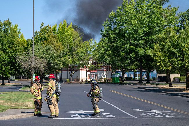 Rusty Rae/News-Register##Firefighters responding to the blaze are seen in the WinCo parking lot Tuesday. The store and many other nearby businesses were evacuated and closed Tuesday. Rusty Rae/News-Register##Firefighters responding to the blaze are seen in the WinCo parking lot Tuesday. The store and many other nearby businesses were evacuated and closed Tuesday.