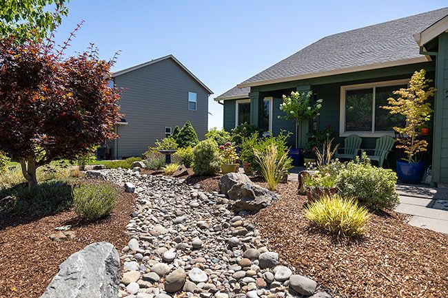 Rachel Thompson/News-Register##A dry creek bed bisects Lori and John Wallick’s front yard on Redmond Hill Road, leaving plenty of room for flowers and shrubs on either side. The place was named Yard of the Month for August by the McMinnville Garden Club. Rachel Thompson/News-Register##A dry creek bed bisects Lori and John Wallick’s front yard on Redmond Hill Road, leaving plenty of room for flowers and shrubs on either side. The place was named Yard of the Month for August by the McMinnville Garden Club.