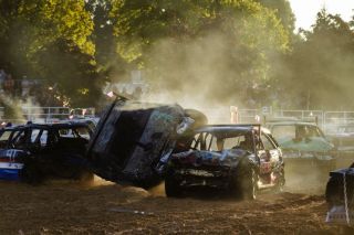 A camo car driven by Jamie Tester, a member of the Sullenger lineage, flips on its side after being struck in the front left wheel by a competitor during the demolition derby held inside the Cascade Arena at the Yamhill County Fair on Saturday, August 2. Tester left the ring under her own care and was not injured. According to the drivers, vans are easier to flip because they are top heavy, but Tester’s small car was the only one to tilt over during the events.
Rachel Thompson/News-Register