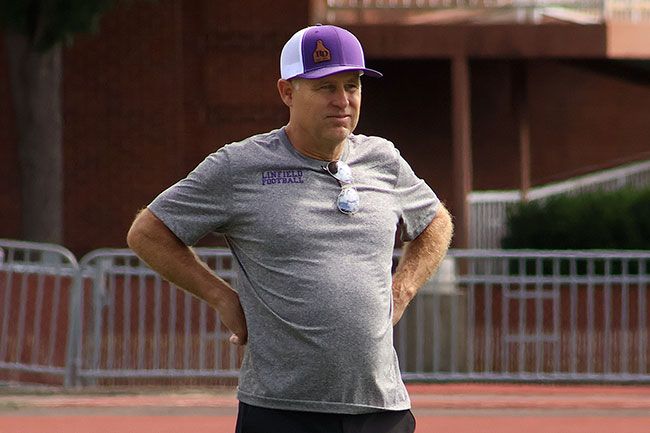 Nathan Ecker/News-Register##Coach Smith watches as his players run the 40-yard dash. The first day of practice began in the late morning and included agility training, stretching and timed sprints as the Wildcats got back into football shape. Many players have been training for weeks ahead of time, but the initial day of activity allows guys to slowly get back on the field while returning to campus.