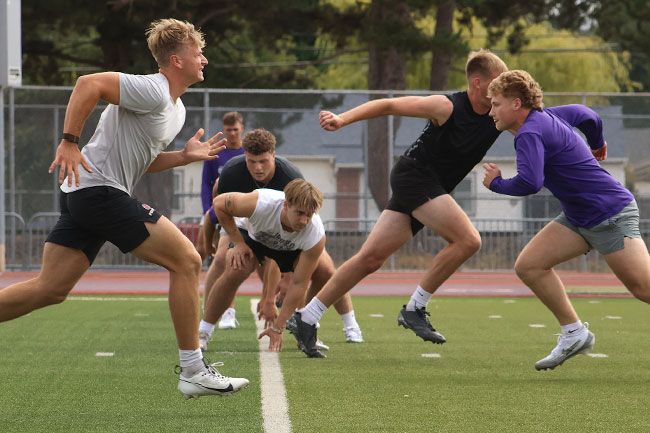 Nathan Ecker/News-Register##Players run back and forth in 10-yard increments during a drill where they alternate directions while starting from a crouched position.