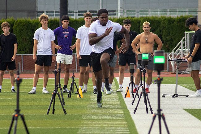 Nathan Ecker/News-Register##A Wildcat runs the 40-yard dash as teammates look on from behind. Linfield captured the Northwest Conference title in 2024, going 10-2, but fell short of a Division III championship when they lost to Mary Hardin-Baylor in the second round of play.