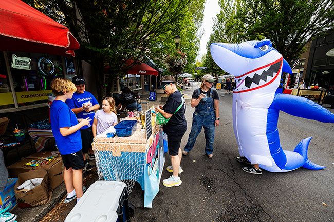 Rachel Thompson/News-Register##Keaton Boice and Drew Moorehead, both 10, run their award-winning shark-themed lemonade stand outside Joysticks Arcade on Third Street during Lemonade Day on Saturday. Keaton’s sister Indi, 6, assisted. Friend Kade Baynes in a shark costume danced and called out “Buy Shark-a-nade!” to attract customers, including Janice Blumer of McMinnville and her daughter, Gillian, visiting from Monterey, California. The boys won first place in the “Best of the Zest” contest. Rachel Thompson/News-Register##Keaton Boice and Drew Moorehead, both 10, run their award-winning shark-themed lemonade stand outside Joysticks Arcade on Third Street during Lemonade Day on Saturday. Keaton’s sister Indi, 6, assisted. Friend Kade Baynes in a shark costume danced and called out “Buy Shark-a-nade!” to attract customers, including Janice Blumer of McMinnville and her daughter, Gillian, visiting from Monterey, California. The boys won first place in the “Best of the Zest” contest.