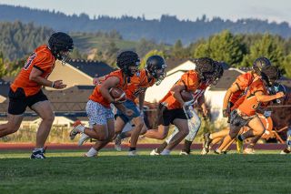 Yamhill Carlton players run down the field during their first practice at Yamhill Carlton High School on Monday, August 18. Holding footballs in the photo are seniors Tyler Pond and Jackson Mitchell, the Tigers’ key backfield pieces who are prepared to take on a larger role in the offense this season.##Nathan Ecker/News-Register Yamhill Carlton players run down the field during their first practice at Yamhill Carlton High School on Monday, August 18. Holding footballs in the photo are seniors Tyler Pond and Jackson Mitchell, the Tigers’ key backfield pieces who are prepared to take on a larger role in the offense this season.##Nathan Ecker/News-Register