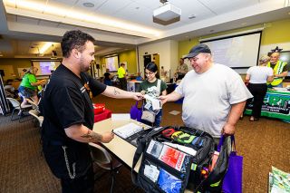 Rachel Thompson/News-Register## Jennifer Suarez and her father, Andres Suarez, of Sheridan learn about Jeremy Grow’s EMT business, GATES Medical Services. Grow provides on-site medical services for festivals, concerts, social gathering and business events. He shared information about basic first aid and his services with the public during the Emergency Preparedness Resource Fair last week at the Chemeketa Community College Yamhill Valley Campus.