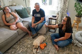 Rusty Rae/News-Register$$Jenna Mosley describes how the Seeds of Hope program helped her family while her husband, Lance Mosley, center, was undergoing cancer treatments. Their daughter, Liberty, called her dad “the strongest man I know.” Bobba the pug is also shown. Rusty Rae/News-Register$$Jenna Mosley describes how the Seeds of Hope program helped her family while her husband, Lance Mosley, center, was undergoing cancer treatments. Their daughter, Liberty, called her dad “the strongest man I know.” Bobba the pug is also shown.