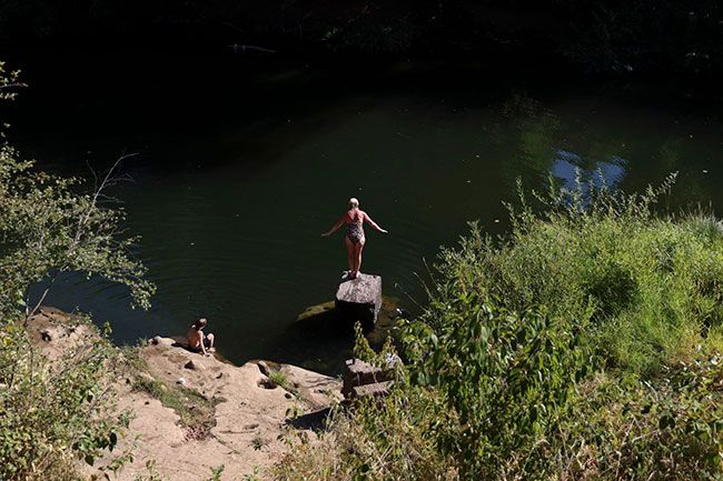 Amanda Loman/InvestigateWest##A woman prepares for a swim in South Yamhill River in Sheridan. Stella-Jones&rsquo; wood treatment facility has a state permit that allows it to release treated stormwater into the river, but the company has repeatedly violated the permit by releasing water containing excessive amounts of a wood preservative known as pentachlorophenol.