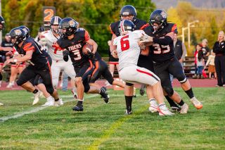 Tyler Pond (No. 35) helps lay down a block for junior wide receiver Nick Titular (No. 3) on a rushing attempt up the middle of the field during the Tigers game against Santiam Christian and Laughlin Stadium on Friday, Sept. 12.##Rachel Thompson/News-Register