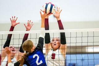 Rusty Rae/News-Register##Dayton senior Katie Freeborn and sophomore Gabby Chupp reach above the net for a block attempt on a ball hit by Amity freshman middle blocker Adelynne Slowik during the rivalry matchup at Dayton High School.