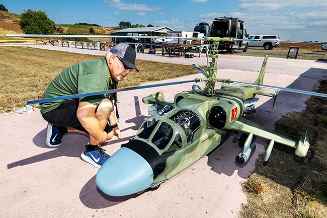 Rachel Thompson/News-Register##Gonzalo Martinez of the San Francisco area, who founded the Helicopter Scale Masters fly-in, looks over his rare Russian Kamov Ka-52 combat model. This is the first time the fly-in has been held outside Davis, California; it will return to McMinnville again in 2026, and an additional McMinnville Aircraft Modelers event will be held at the airfield on Masonville Road in October. Rachel Thompson/News-Register##Gonzalo Martinez of the San Francisco area, who founded the Helicopter Scale Masters fly-in, looks over his rare Russian Kamov Ka-52 combat model. This is the first time the fly-in has been held outside Davis, California; it will return to McMinnville again in 2026, and an additional McMinnville Aircraft Modelers event will be held at the airfield on Masonville Road in October.
