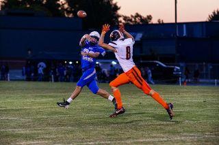 Senior quarterback Jackson Walker extends to his right on a pass attempt while scrambling out the pocket to avoid pressure against Scio in the Warriors home match at Amity High School on Friday, Sept. 19.##Nathan Ecker/News-Register