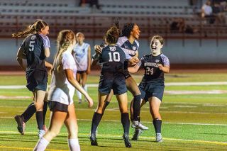 Grizzlies midfielder Mayeli Wilson celebrates her first varsity goal against McDaniel on Tuesday, Sept. 23 at Wortman Stadium. Teammates Hallie Vaughan (No. 10) and 	Savannah Bosworth (No. 23) were the first to pile around Wilson.##Nathan Ecker/News-Register