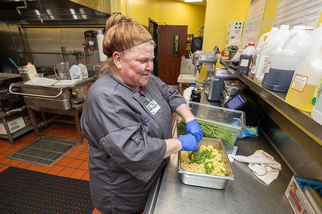 Rachel Thompson/News-Register##Kari Edie, director of food and nutrition at Willamette Valley Medical Center, makes a salad with pasta and assorted vegetables. In addition to making salads and desserts for the hospital cafe, she oversees the staff and the special diets for patients with various medical needs.