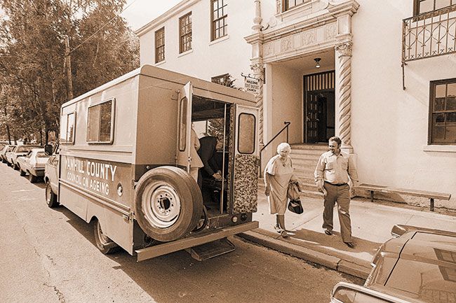 (Sept. 24, 1980) Richard Hawes, driver for the Council on Aging, helps some of his regular customers into the council’s van after a visit to the Pioneer Pantry. Van carries a maximum of 11 people.