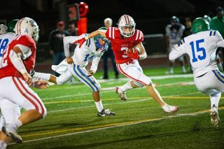 Senior Grant Yochum drives the ball into the red zone, speeding past several McKay defenders during Mac’s homecoming game on Friday, Sept. 26 at Wortman Stadium. Yochum scored the Grizzlies first touchdown on a rushing attempt and later found the endzone on a two-point conversion.##Rusty Rae/News-Register
