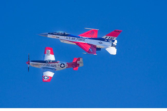 Rachel Thompson/News-Register##An F-16 Fighting Falcon and a P-51 Mustang fly side by side in a the Oregon International Air Show. The modern Viper Demo Team jet joined “Val-Halla,” a WWII-era Mustang, to honor U.S. Air Force servicemembers and showcase the evolution of military aviation.