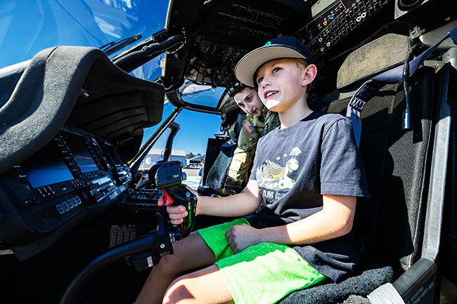 Rachel Thompson/News-Register##Christopher Blaser, 9, of West Linn, takes the pilot’s seat in a UH-60M Black Hawk helicopter. Sgt. Thomas Pinheiro of the Oregon Army National Guard led cockpit tours of the rescue aircraft, which is used for medevac and search-and-rescue missions across the Cascades.