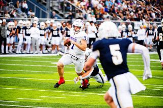 Luke McNabb looks down field and away from the outstretched arms of a George Fox defender during the ‘Cats 35-15 victory over the Bruins at Stoffer Family Stadium on Saturday, Oct. 4.##Rusty Rae/News-Register Luke McNabb looks down field and away from the outstretched arms of a George Fox defender during the ‘Cats 35-15 victory over the Bruins at Stoffer Family Stadium on Saturday, Oct. 4.##Rusty Rae/News-Register