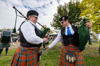 Rachel Thompson/News-Register##Oak Nelson of the Tacoma Scots Pipe Band tunes the bagpipes of Tamara Crane, left, ahead of Saturday’s March Medley competition during the McMinnville Scottish Festival. The group tunes their pipes to a bright pitch of 480 Hz to achieve the sharp, resonant sound characteristic of traditional Highland music.