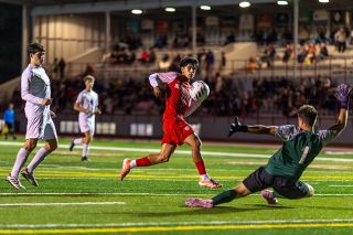 Junior forward Edwin “Isiai” Cuevas-George watches as the ball deflects off of Newberg’s goalkeeper during the Grizzlies’ match against the county foe at Wortman Stadium on Wednesday, Oct. 8. Isiai uncorked several hard shots, many of which Newberg’s keeper had trouble handling.##Rachel Thompson/News-Register