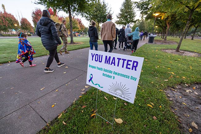 Rachel Thompson/News-Register##Attendees walk the path at Discovery Meadows Park during Thursday’s Out of Darkness Sunrise Vigil in honor of Oregon Youth Suicide Awareness Day. Signs along the trail offered messages of hope, including “Tomorrow needs you” and “Stay; your story’s not finished yet,” as the community came together to remember Mikalynn Morris and surround local youth with love and support. Rachel Thompson/News-Register##Attendees walk the path at Discovery Meadows Park during Thursday’s Out of Darkness Sunrise Vigil in honor of Oregon Youth Suicide Awareness Day. Signs along the trail offered messages of hope, including “Tomorrow needs you” and “Stay; your story’s not finished yet,” as the community came together to remember Mikalynn Morris and surround local youth with love and support.